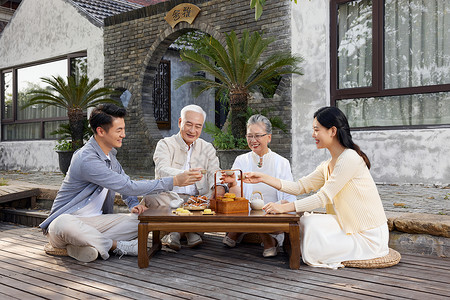 新婚夫妻陪伴老人过中秋节喝茶背景图片