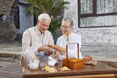 中秋节爷爷奶奶庭院里喝茶背景图片