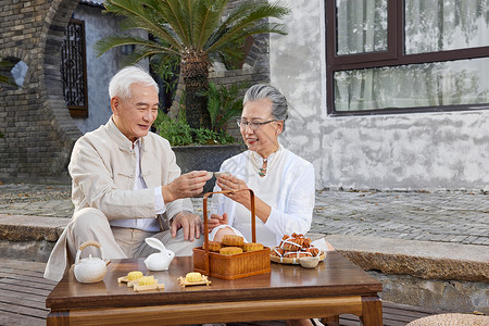 中秋节爷爷奶奶庭院里喝茶背景图片