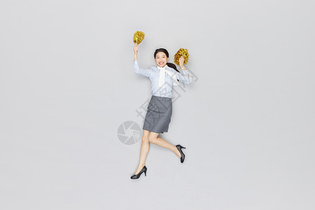 创意俯拍商务女性拿拉拉队手摇花加油图片