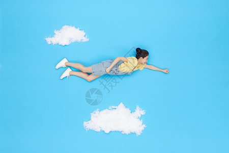 创意俯拍美女云朵上飞行旅行图片