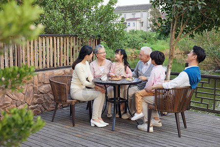 呵护一家人一家人坐在庭院里过中秋节背景
