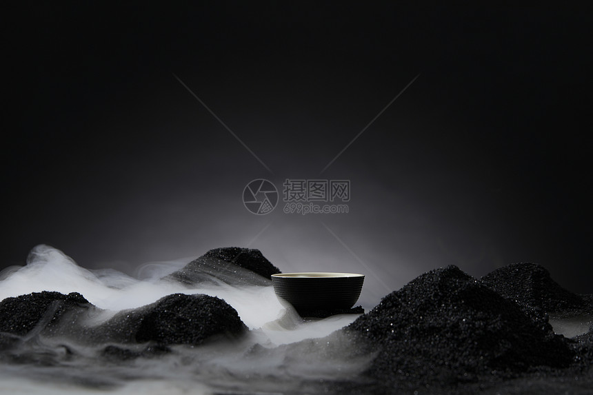 黑色背景下的干冰和茶杯图片