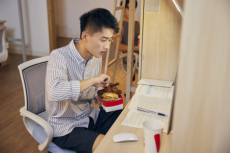 边吃炸鸡写作业的男大学生图片