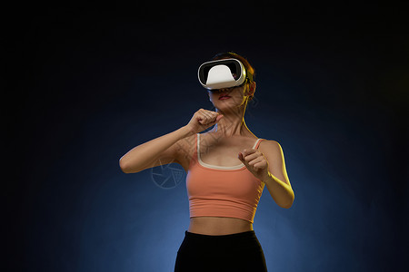 打VR拳击运动游戏的年轻女青年高清图片