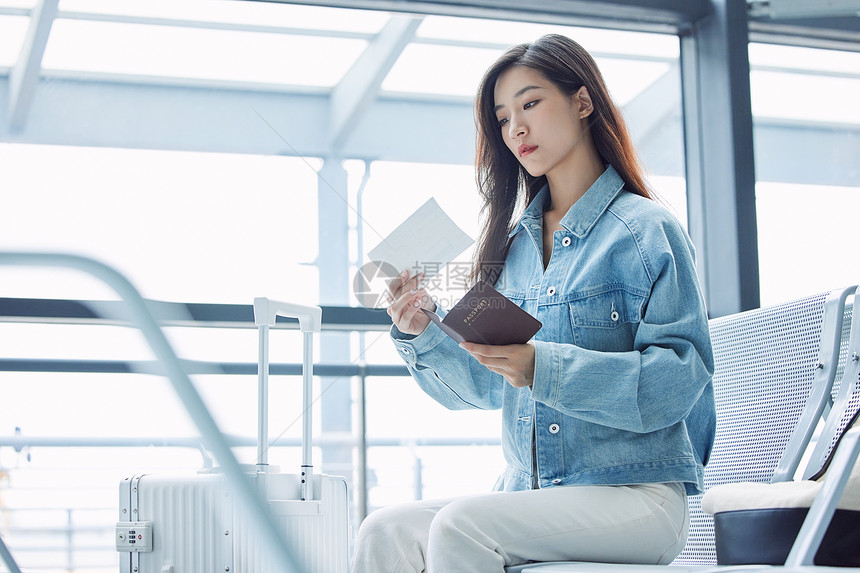 旅游出行的年轻女性手拿机票和护照图片