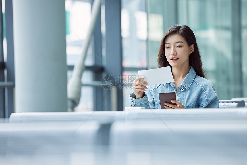 旅游出行的年轻女性手拿机票和护照图片