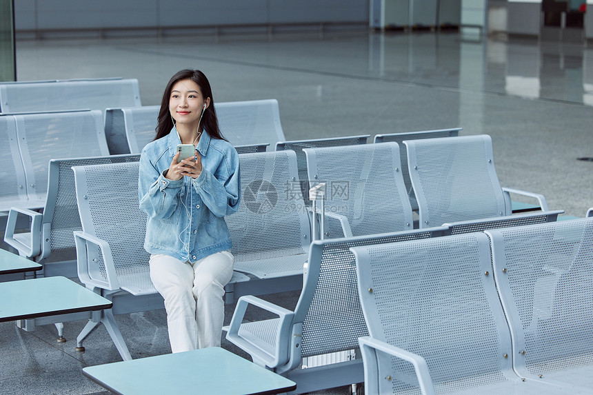机场使用手机的女性图片