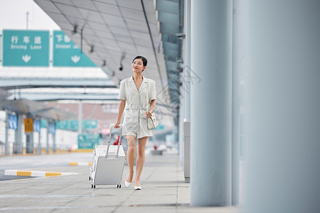拉着行李走在机场外的职场女性高清图片