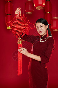 举着中国结的穿旗袍的年轻女子图片