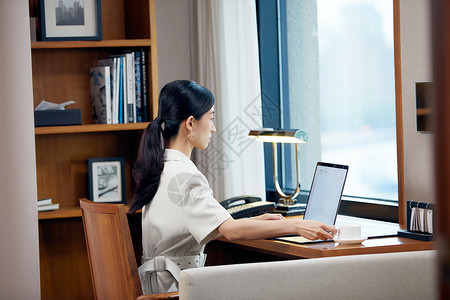 酒店书桌办公的商务女性图片
