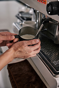 咖啡师向牛奶内打蒸汽制作奶泡图片