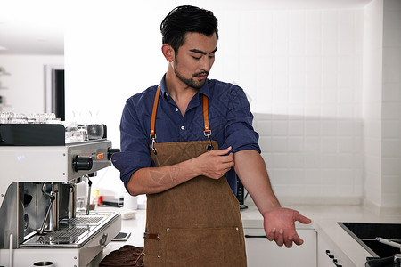 男性咖啡师整理衣袖背景图片