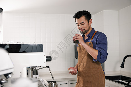 男性咖啡师观察手中的咖啡豆罐高清图片