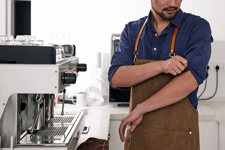 男性咖啡师整理衣袖特写图片