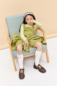 绿裙子穿着成熟裙子小女孩坐椅子上背景