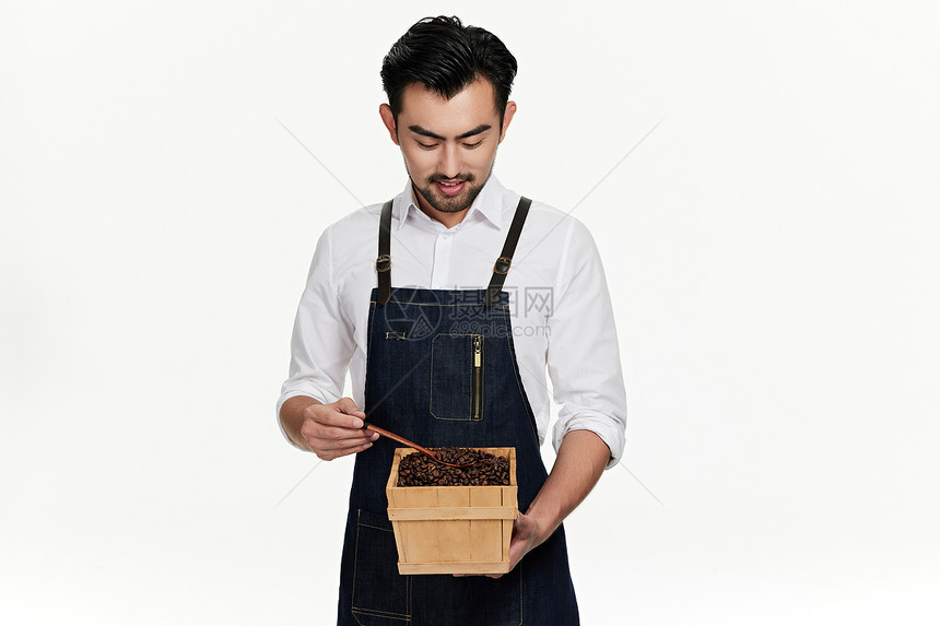 咖啡师用勺子挖取咖啡豆图片