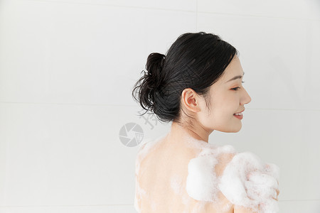 伸胳膊女性使用沐浴球洗澡背景