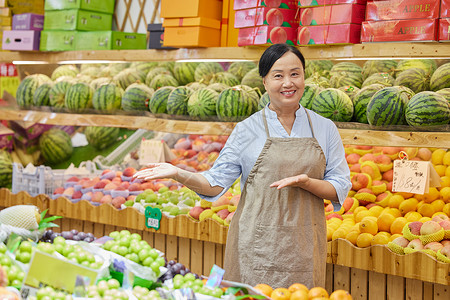 水果店中年女性店员推销水果形象图片