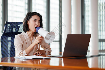 对着电脑工作职场女性拿着扩音器对着电脑大叫背景