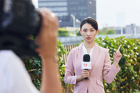 青年女记者户外采访录制图片