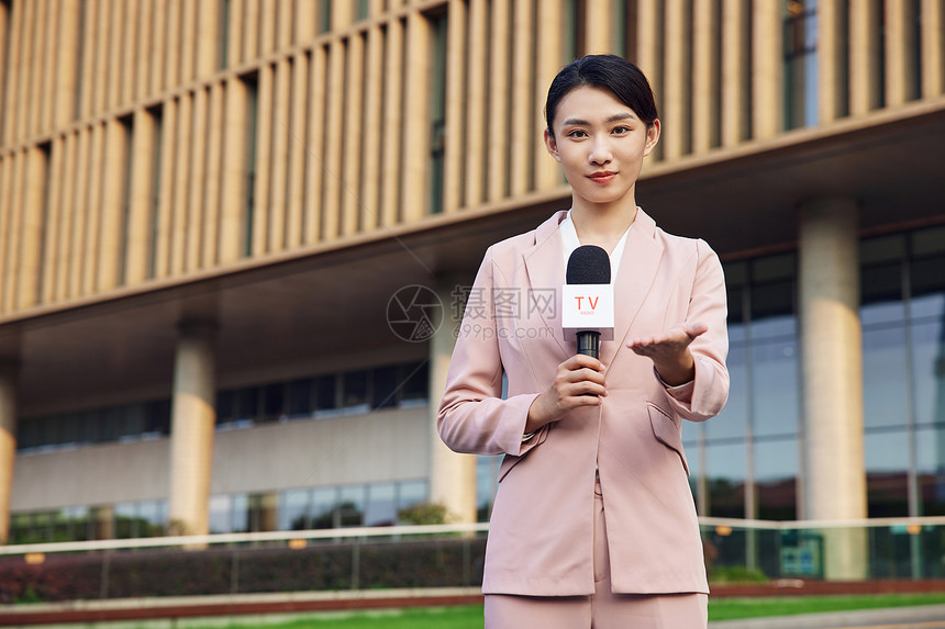 年轻女记者手拿话筒户外采访图片