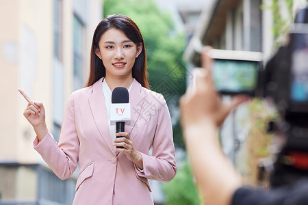 手机看新闻年轻女记者户外录制背景