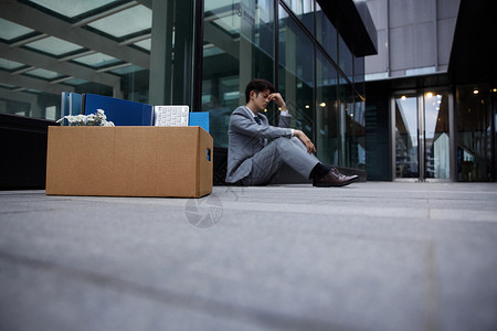 失业下岗的职场商务男性瘫坐在地上高清图片