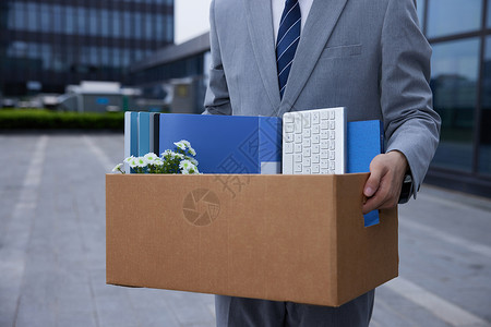 商务男性被开除抱着办公用品纸箱特写图片