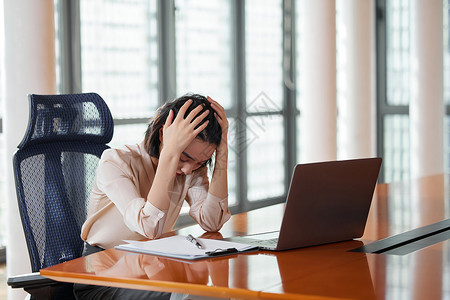 有想法的人电脑前抱着头痛苦的职场女性背景