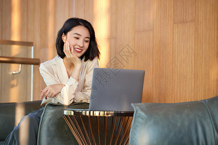 女性在休闲区域使用笔记本电脑背景