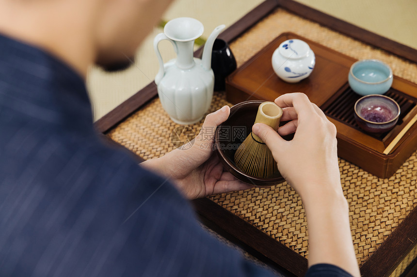 日系男性手拿茶筅筛茶特写图片