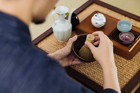 抹茶背景日系男性手拿茶筅筛茶特写背景