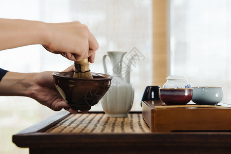 日式茶道茶艺师使用茶筅筛茶特写背景图片