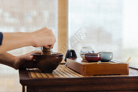 日式茶道茶艺师使用茶筅筛茶特写背景图片