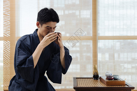 日系男性手拿茶碗喝茶图片