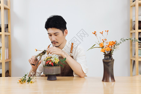 在工作室插花的男性花艺师图片