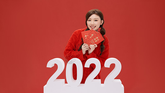 活力女性手拿红包迎接2022年背景图片