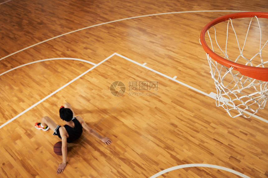 篮球运动员坐在篮球场上休息图片