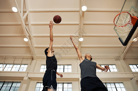 两个篮球运动青年跳起争球图片