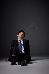 坐在地上悲伤的职场男性高清图片