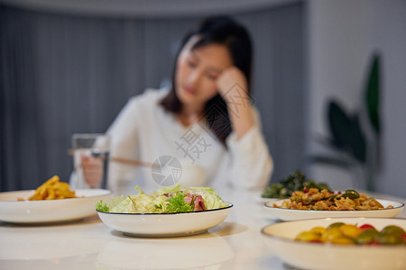 不吃晚饭女性在家一个人吃晚餐背景