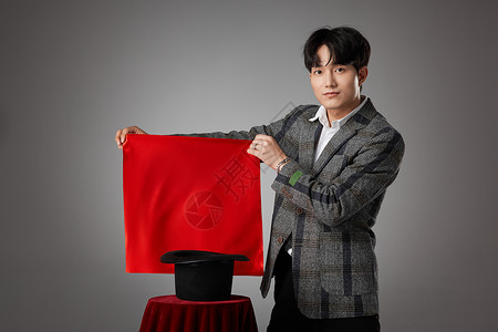 男性魔术师手拿红色方巾正在变魔术高清图片