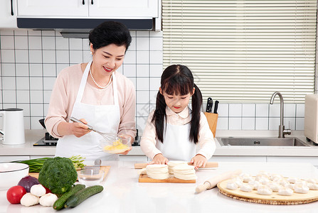 奶奶和孙女一起在厨房包饺子高清图片