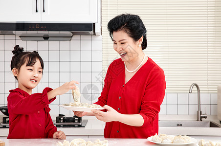 煮饺子女人厨房里奶奶端着煮好的饺子背景