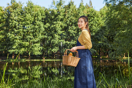 提着篮子的女孩青年美女公园湖边郊游提着篮子背景