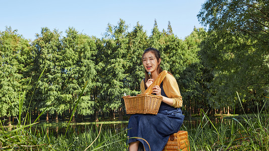 青年大学生野外湖边郊游吃面包图片