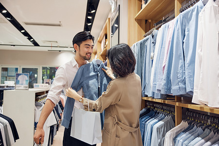 年轻夫妻在商场选购衣服购买高清图片素材