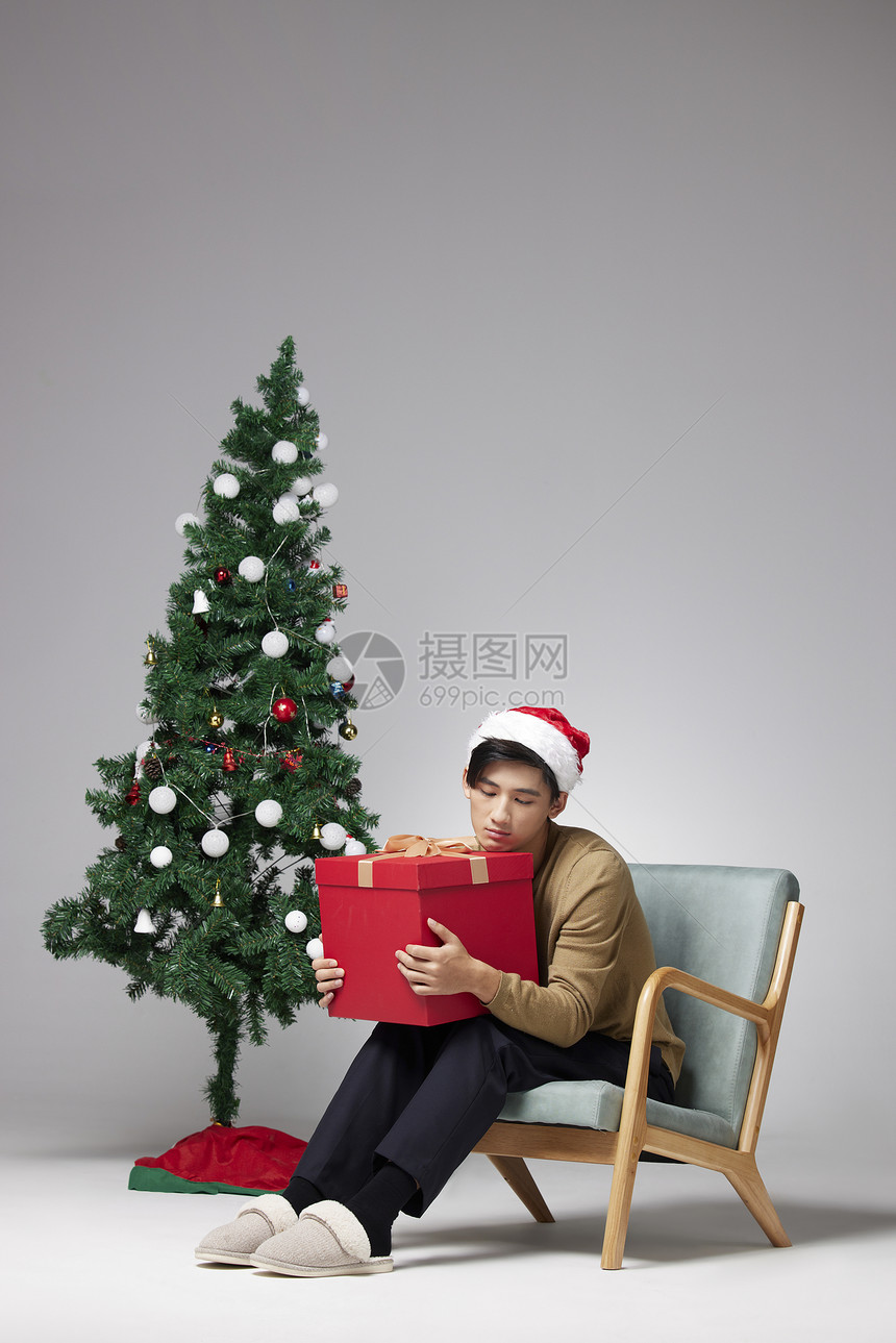 圣诞节男性独自一人抱着礼物盒图片