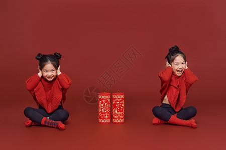 双胞胎小女孩捂耳朵放爆竹背景图片